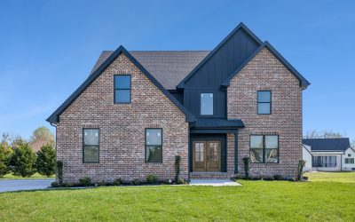 Beautiful brick house with manicured lawn and modern design elements under a clear blue sky.